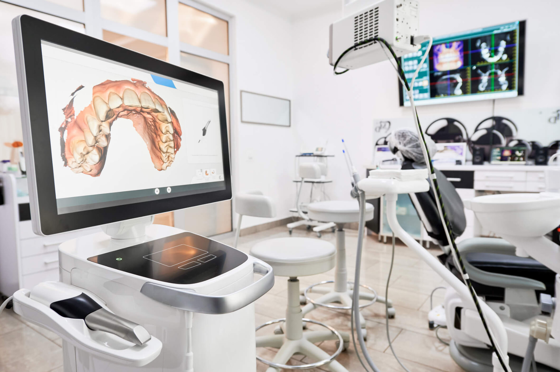 Digital intraoral scanner displaying a 3D model of a patient's dental arch in a treatment room at DC Implant & Cosmetic Dentistry